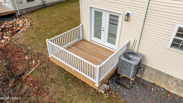 deck featuring french doors, a yard, and central AC unit