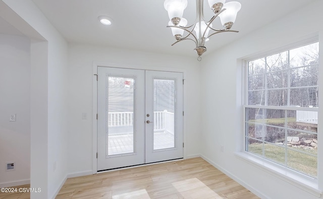 entryway featuring a wealth of natural light, french doors, and light wood-type flooring