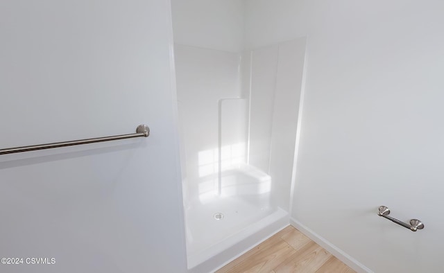 bathroom with a shower and hardwood / wood-style floors