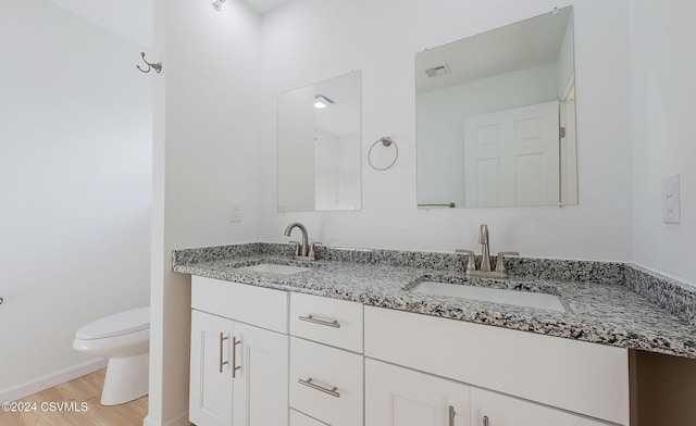 bathroom featuring hardwood / wood-style floors, vanity, and toilet