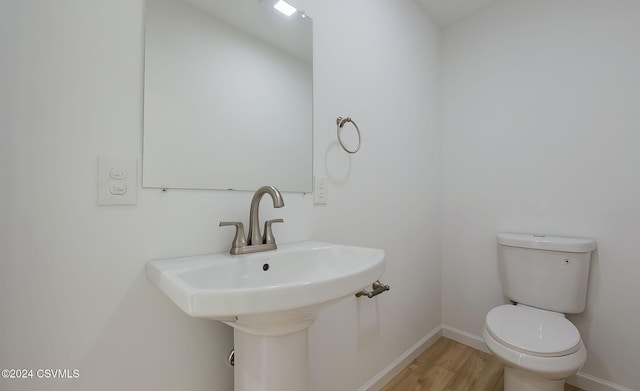 bathroom with hardwood / wood-style flooring, toilet, and sink