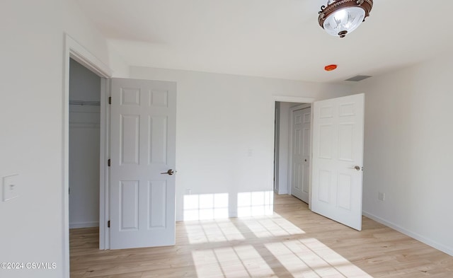 unfurnished bedroom featuring light hardwood / wood-style floors and a closet