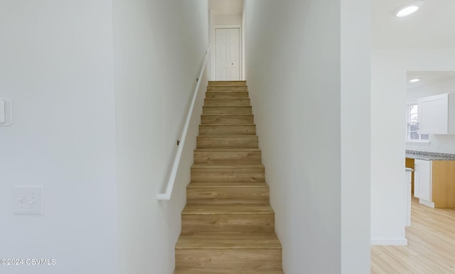 staircase with hardwood / wood-style flooring