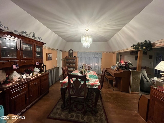 dining area with dark hardwood / wood-style flooring, an inviting chandelier, and vaulted ceiling