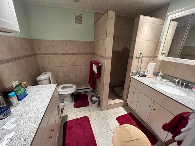 bathroom featuring vanity, tile patterned floors, tile walls, walk in shower, and a baseboard radiator