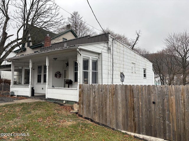 view of side of property with a porch and a yard