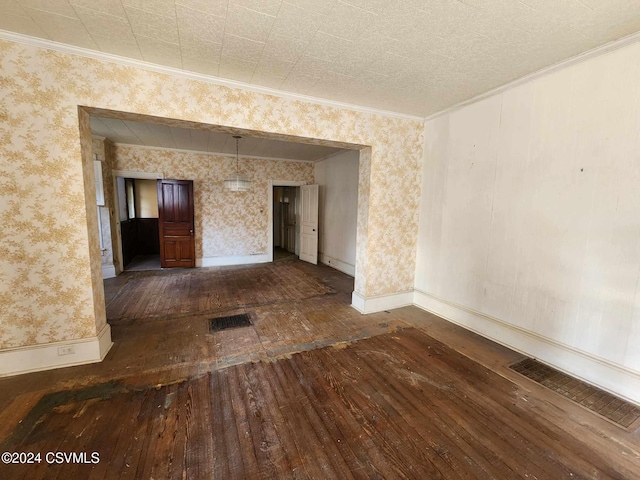 empty room with crown molding and dark wood-type flooring