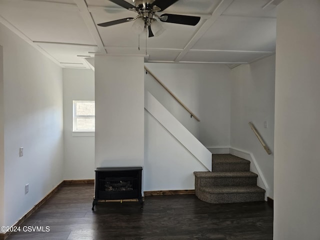 interior space featuring ceiling fan, a wood stove, and dark wood-type flooring