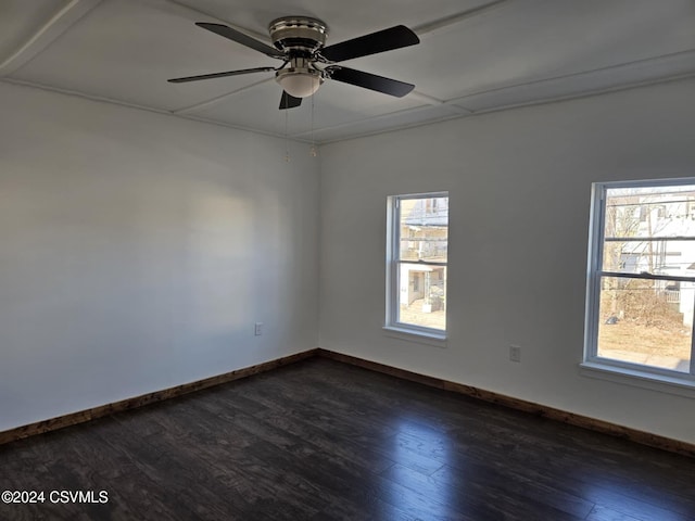 empty room with ceiling fan, dark hardwood / wood-style flooring, and a wealth of natural light