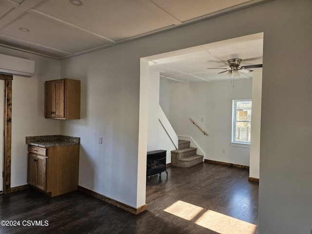 kitchen featuring a wood stove, dark hardwood / wood-style floors, a wall unit AC, and ceiling fan