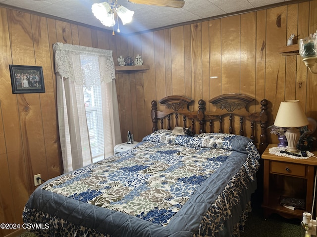 bedroom featuring wooden walls and ceiling fan