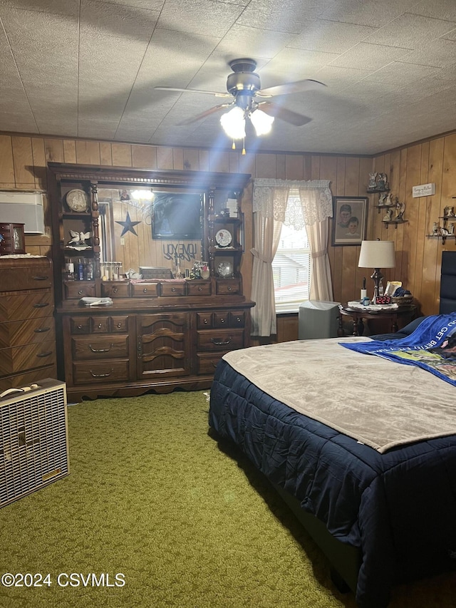 bedroom featuring ceiling fan, wood walls, carpet floors, and a textured ceiling