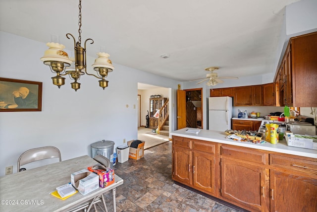 kitchen with white fridge and ceiling fan with notable chandelier