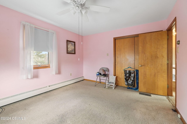 interior space with ceiling fan, baseboard heating, light carpet, and a closet