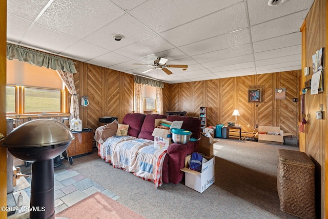 bedroom featuring a drop ceiling, carpet floors, ceiling fan, and wood walls