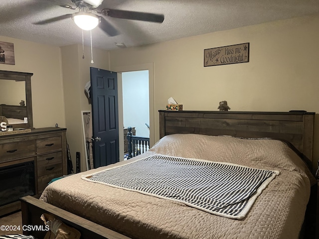 bedroom with a textured ceiling and ceiling fan