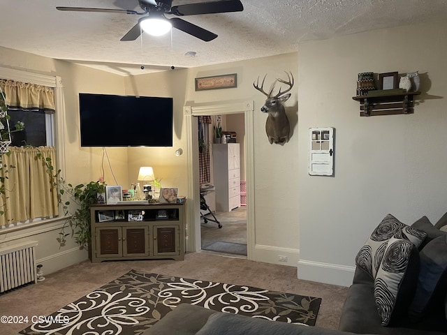 carpeted living room with ceiling fan, a textured ceiling, and radiator