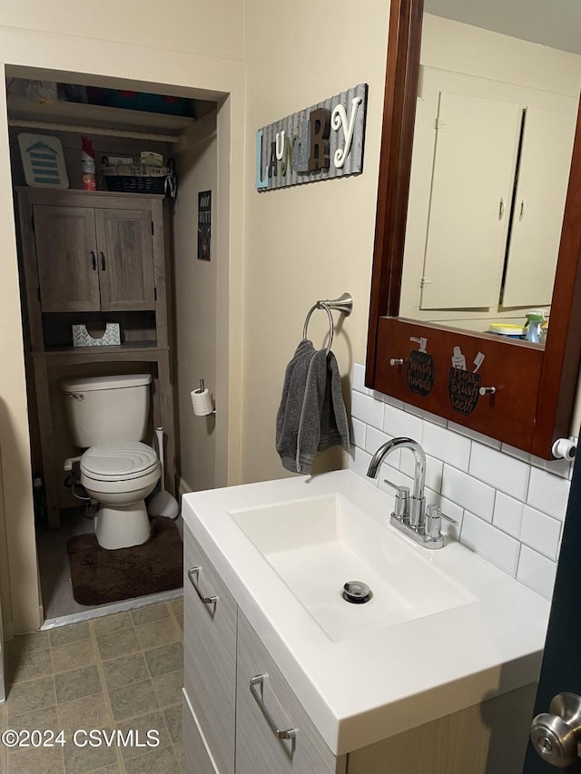 bathroom featuring tasteful backsplash, vanity, and toilet