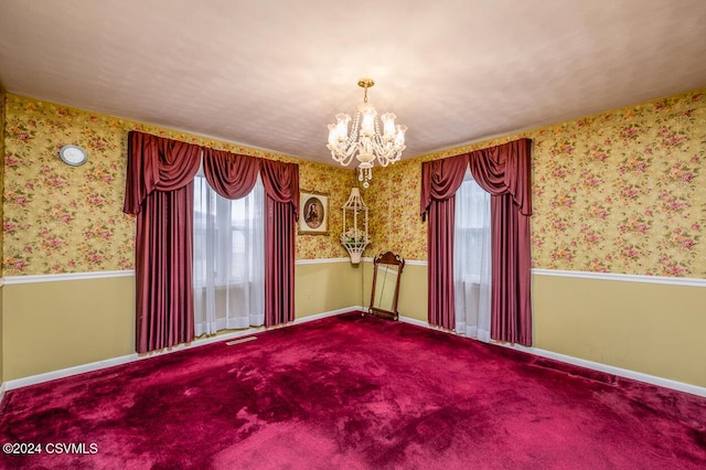 unfurnished room with carpet flooring and a notable chandelier