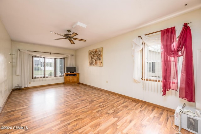 unfurnished living room featuring ceiling fan and hardwood / wood-style floors