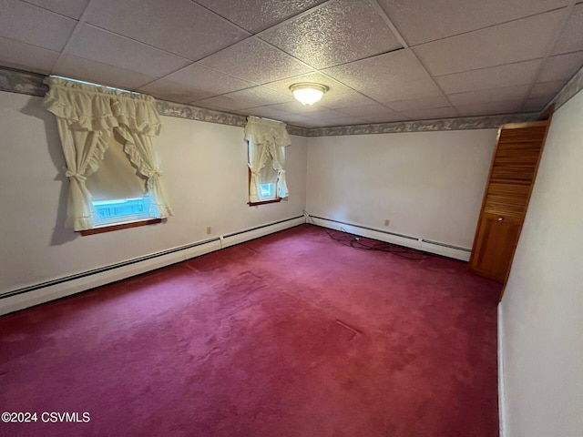 carpeted empty room featuring a drop ceiling