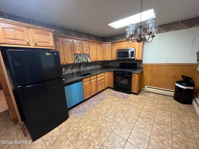 kitchen featuring sink, baseboard heating, a chandelier, wooden walls, and black appliances