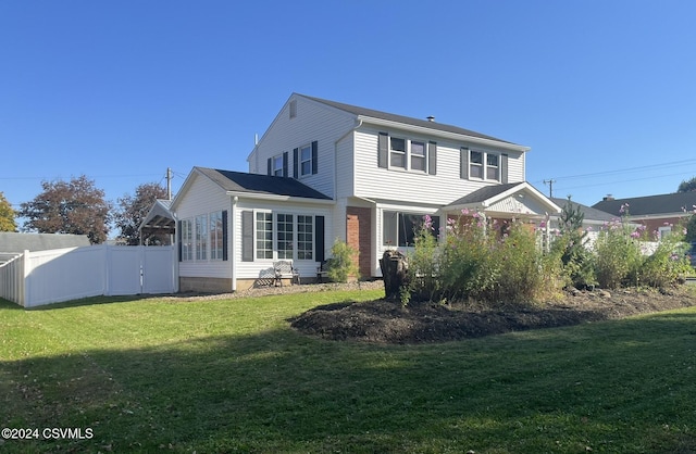 rear view of property featuring a lawn