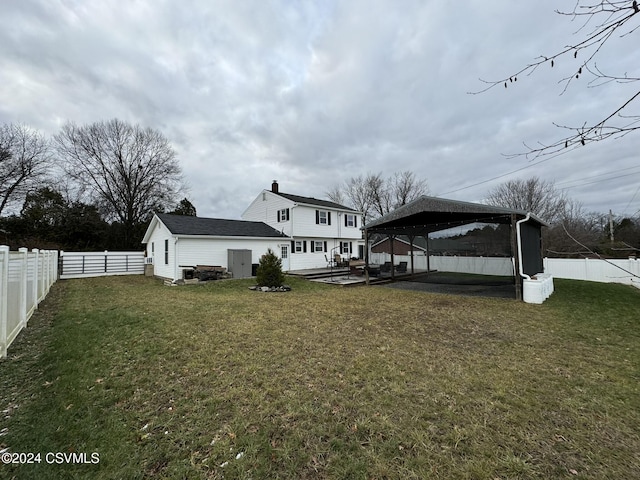 back of property with a gazebo, a wooden deck, and a lawn