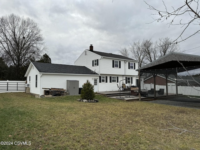 rear view of property with a gazebo, a yard, and a wooden deck