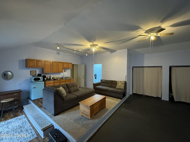 living room featuring hardwood / wood-style flooring, vaulted ceiling, and ceiling fan