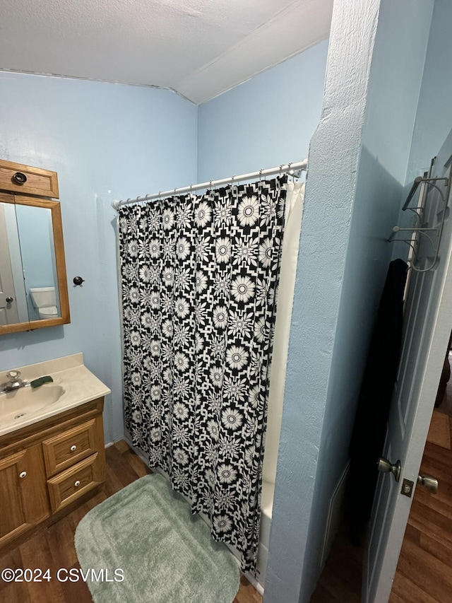 bathroom featuring hardwood / wood-style flooring, vanity, and shower / tub combo