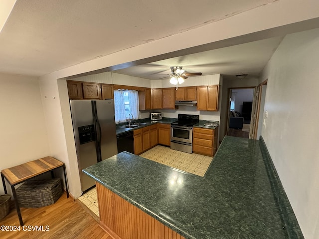 kitchen featuring sink, ceiling fan, light wood-type flooring, kitchen peninsula, and stainless steel appliances