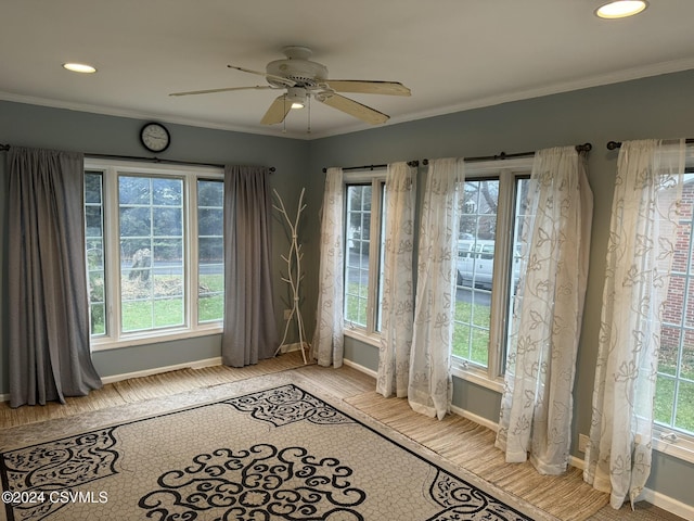 interior space featuring plenty of natural light, light hardwood / wood-style floors, ornamental molding, and ceiling fan