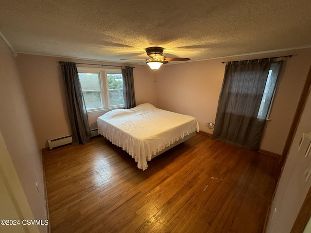 bedroom with a baseboard heating unit, a textured ceiling, ceiling fan, and dark wood-type flooring