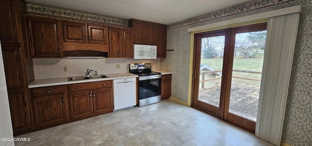 kitchen featuring dark brown cabinets, white appliances, and sink