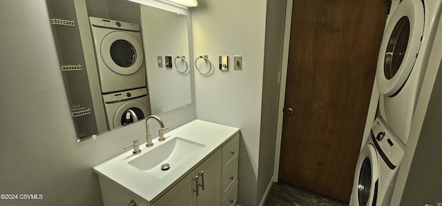 clothes washing area featuring sink and stacked washer / dryer