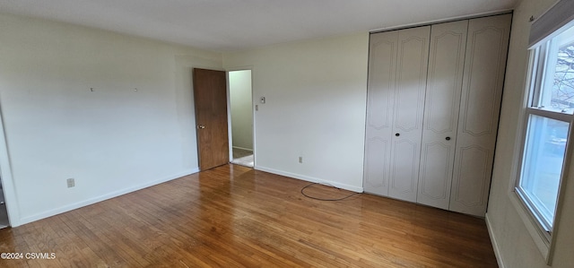 unfurnished bedroom with light hardwood / wood-style floors and a closet