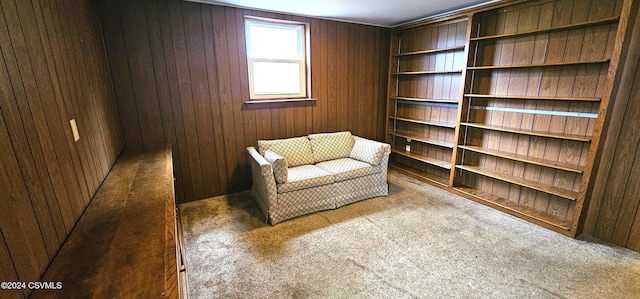 living area featuring wood walls and carpet floors