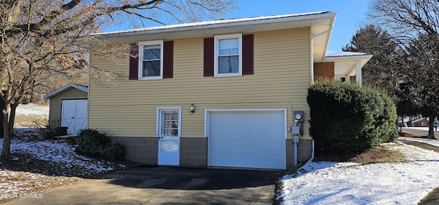 view of snow covered exterior featuring a garage