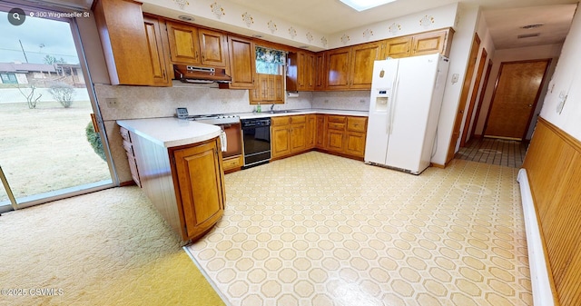 kitchen with exhaust hood, white refrigerator with ice dispenser, sink, stainless steel range oven, and black dishwasher