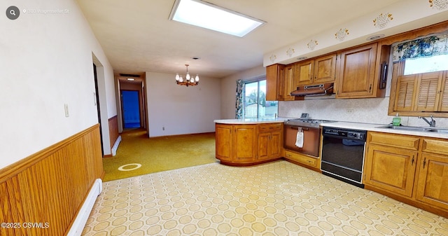 kitchen with kitchen peninsula, wooden walls, pendant lighting, dishwasher, and a chandelier