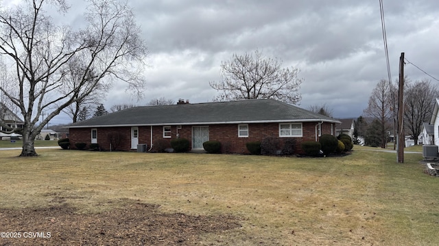 view of front of property with a front lawn and central AC