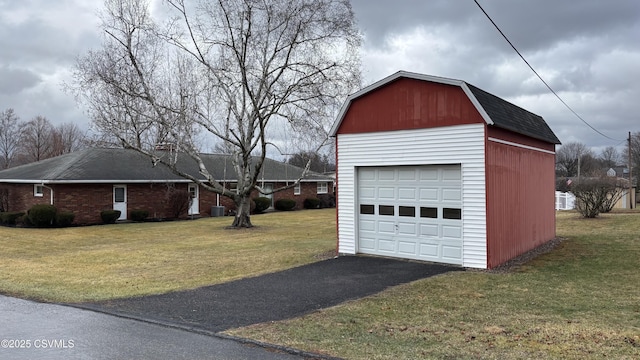 garage featuring central AC unit and a yard