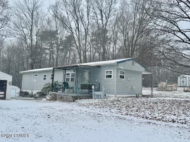 view of front facade featuring a carport and a storage unit