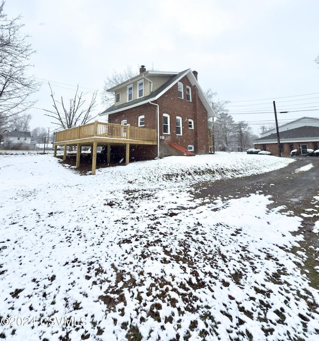 snow covered property with a deck