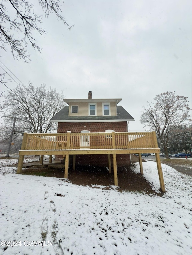 snow covered house with a deck