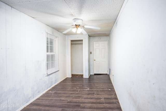 hall featuring dark hardwood / wood-style floors and a drop ceiling