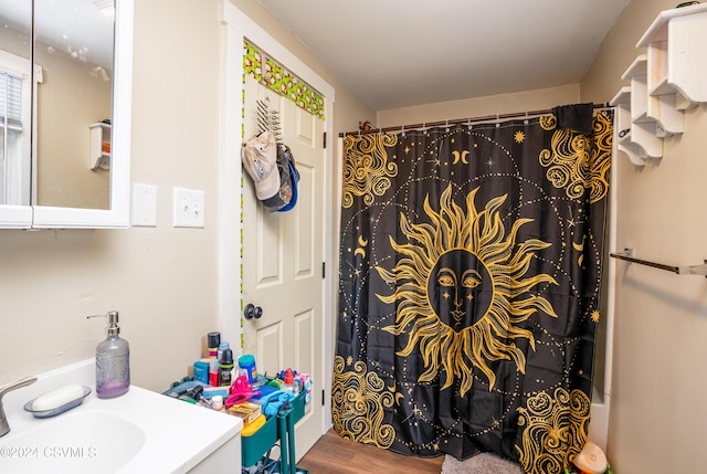 bathroom featuring wood-type flooring, vanity, and curtained shower