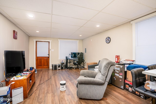 living room featuring a paneled ceiling and wood-type flooring