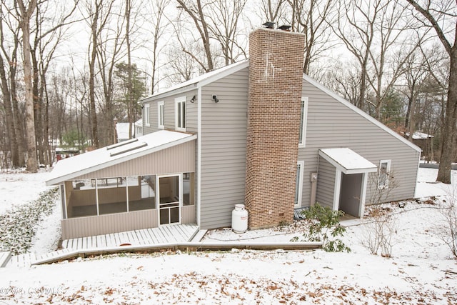 snow covered property with a sunroom